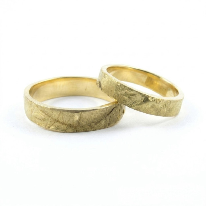 Alianzas de oro con textura de las manos